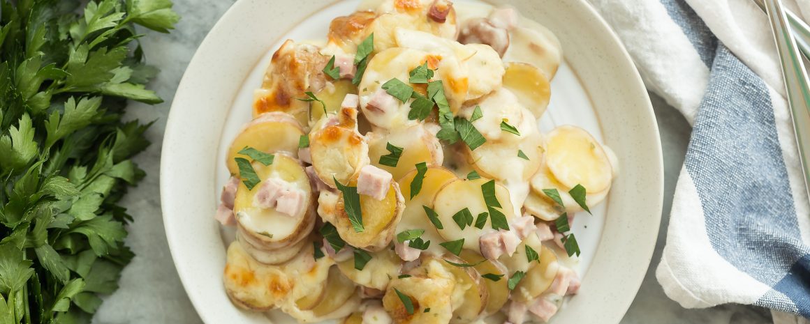 A plate of scalloped potatoes and ham.