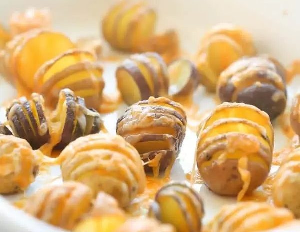 A bowl of little cheesy hasselback potatoes.