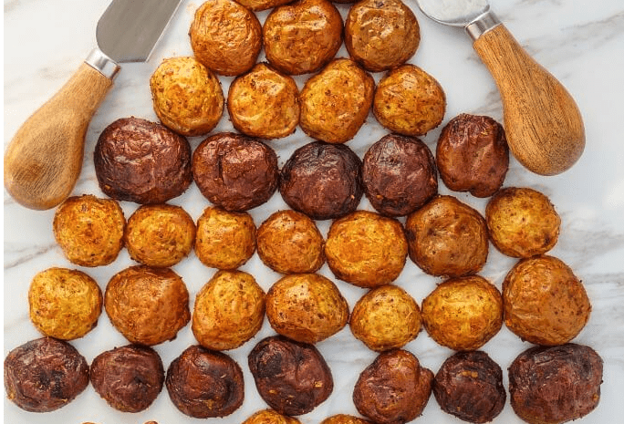 A holiday cheese ball with little potatoes in the shape of a jaunty little Christmas tree.