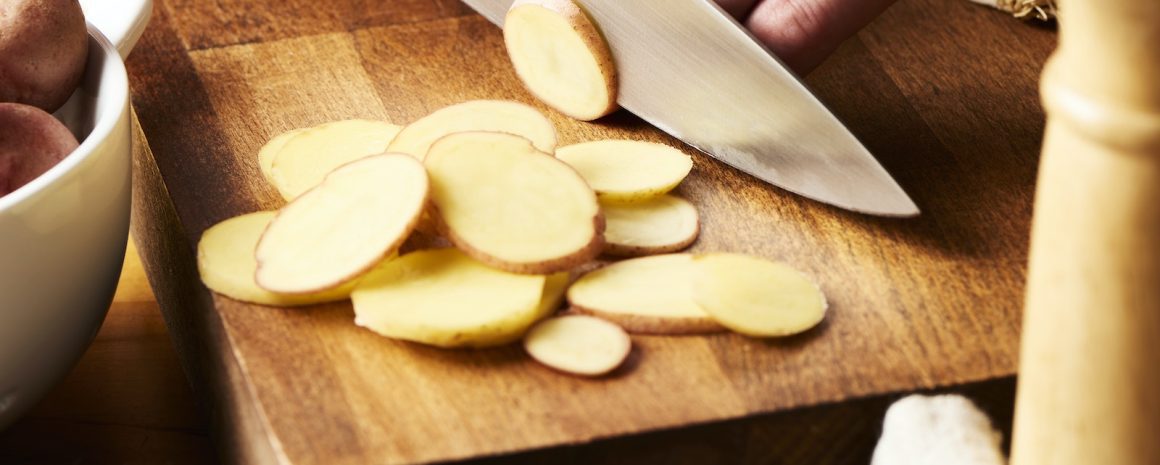 Slicing little potatoes.