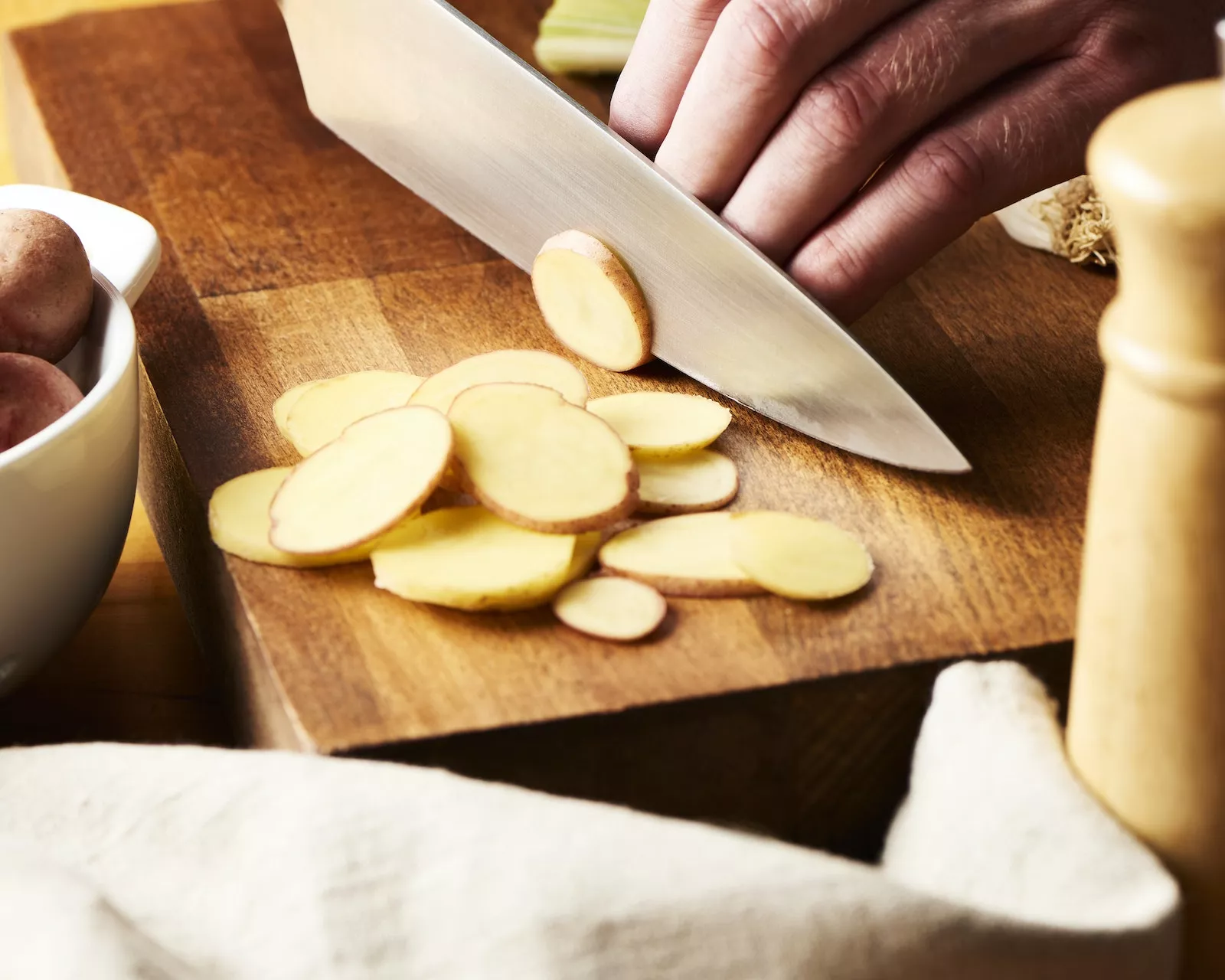 Slicing little potatoes.