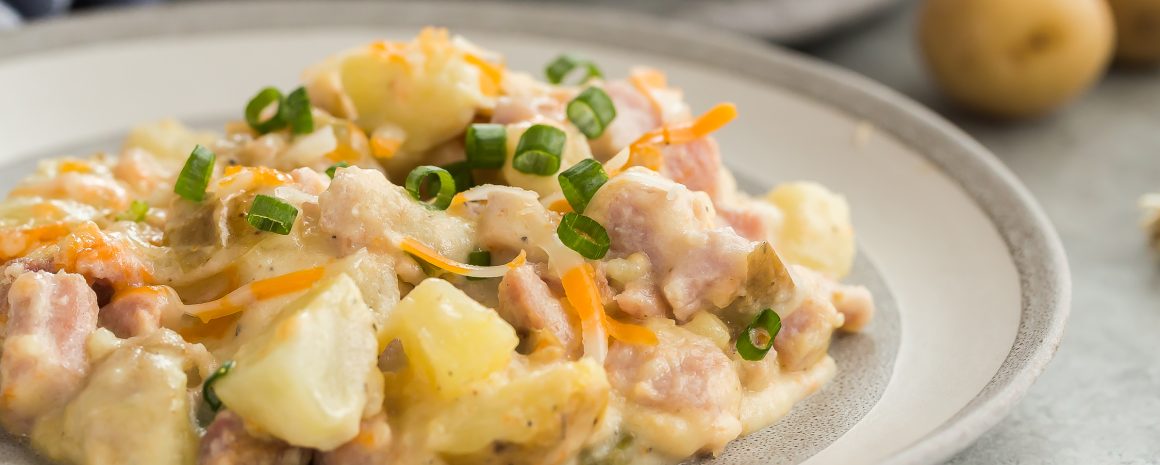 A delicious plate of twice baked potato casserole with ham.