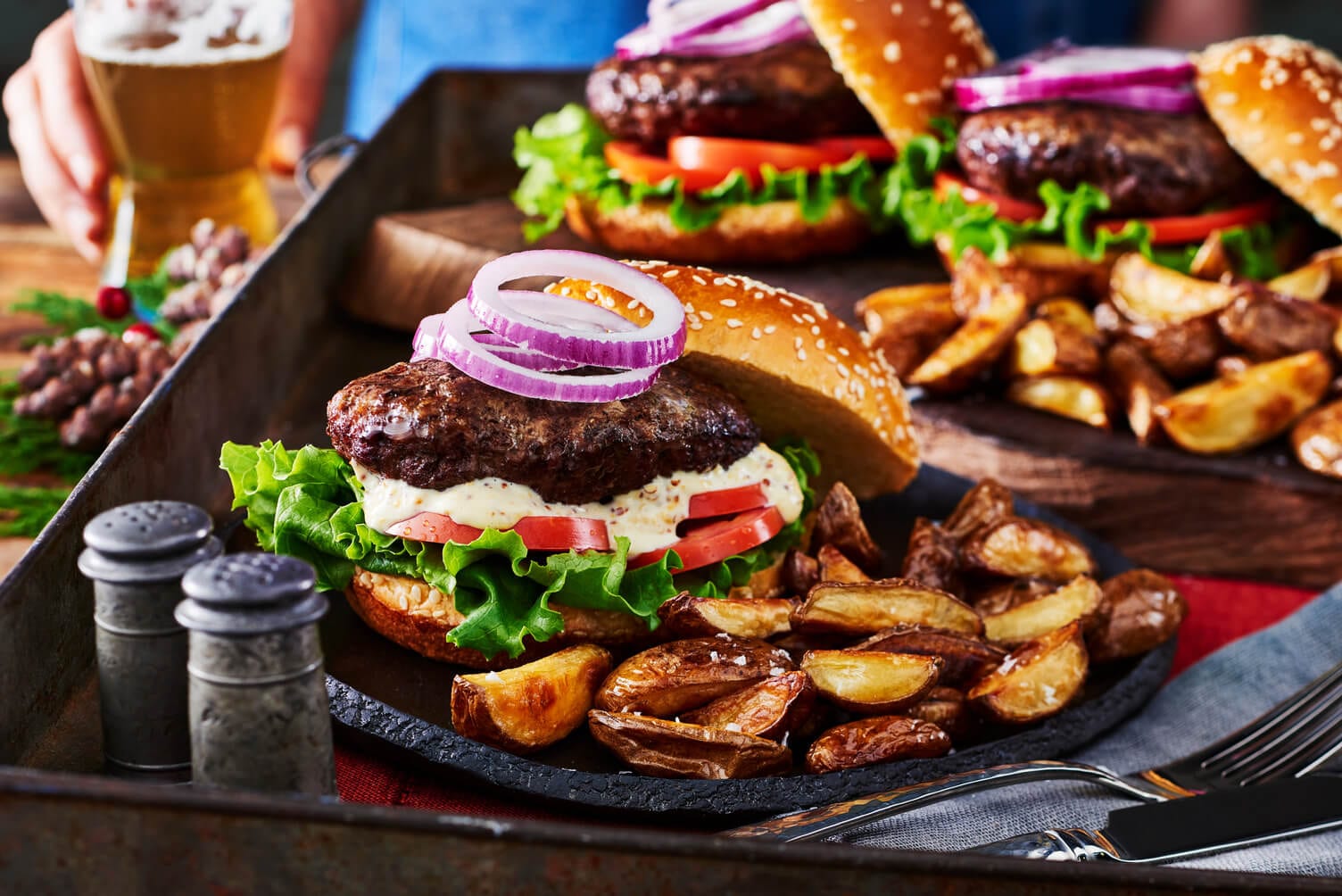 Burgers and mini wedges on a sheet pan.