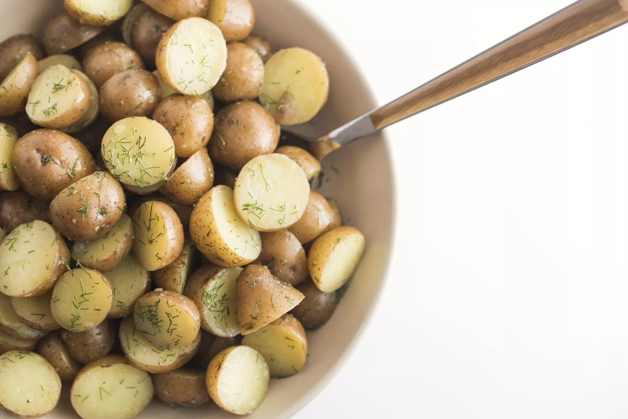 Buttered dill potatoes in a bowl.