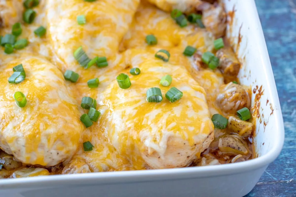 A plate of cheesy barbecue bacon ranch chicken and potatoes.