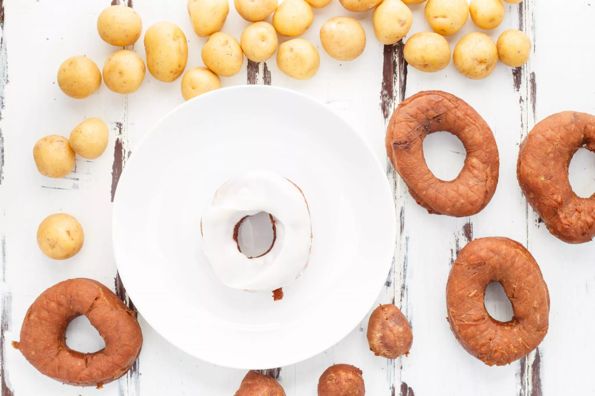 Chocolate potato doughnuts on a plate and a table.