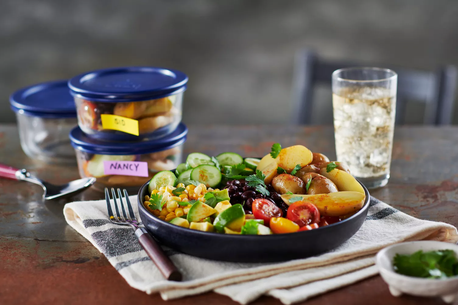 A bowl of fresh delicious salad with potatoes on top.