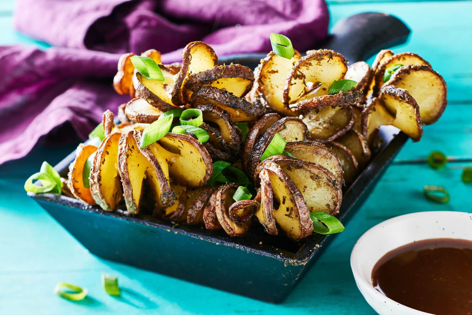 Corkscrew little potatoes in a cute little dish with some sauce on the side.