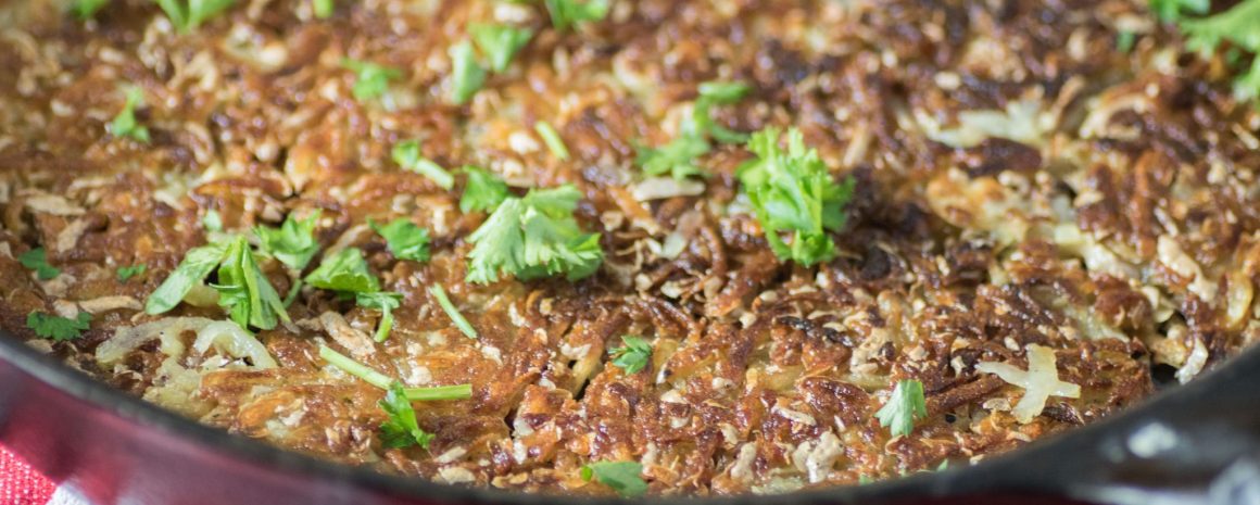 Rosti potatoes in a skillet.