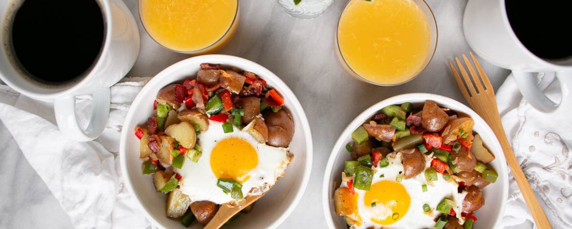 Easy skillet breakfast potatoes in bowls with some orange juice next to it.