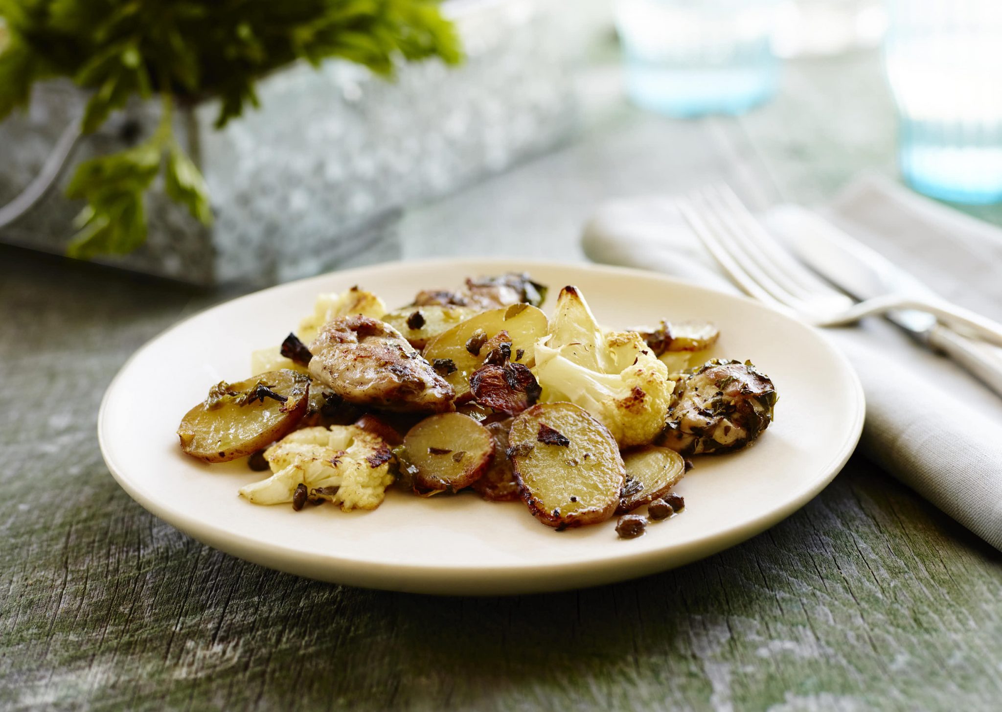 A plate of chicken potatoes and cauliflower.