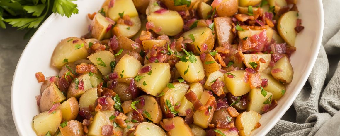 A nice big bowl of German potato salad with lots of bacon bits.