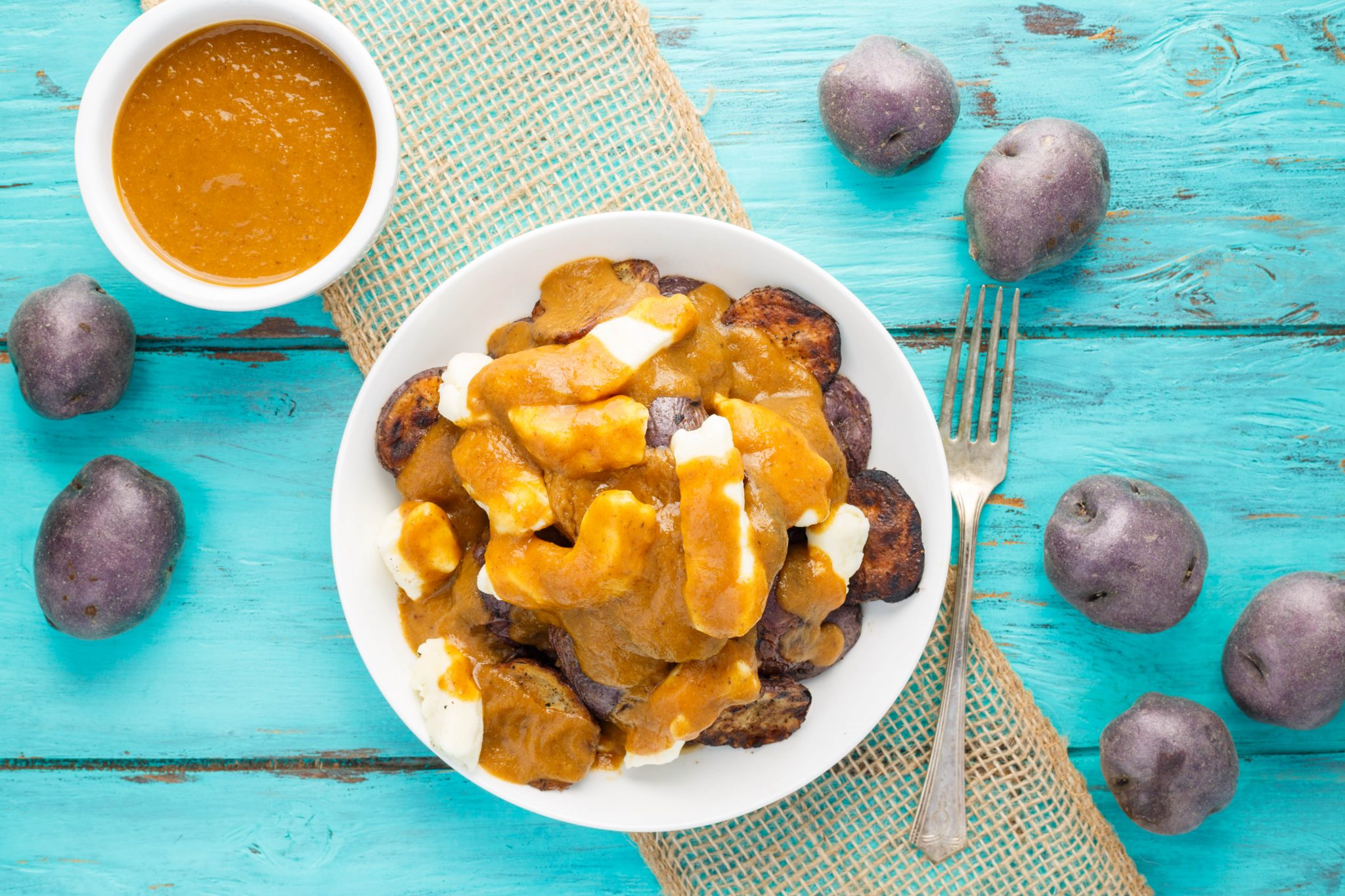 A bowl of grilled little potato poutine.