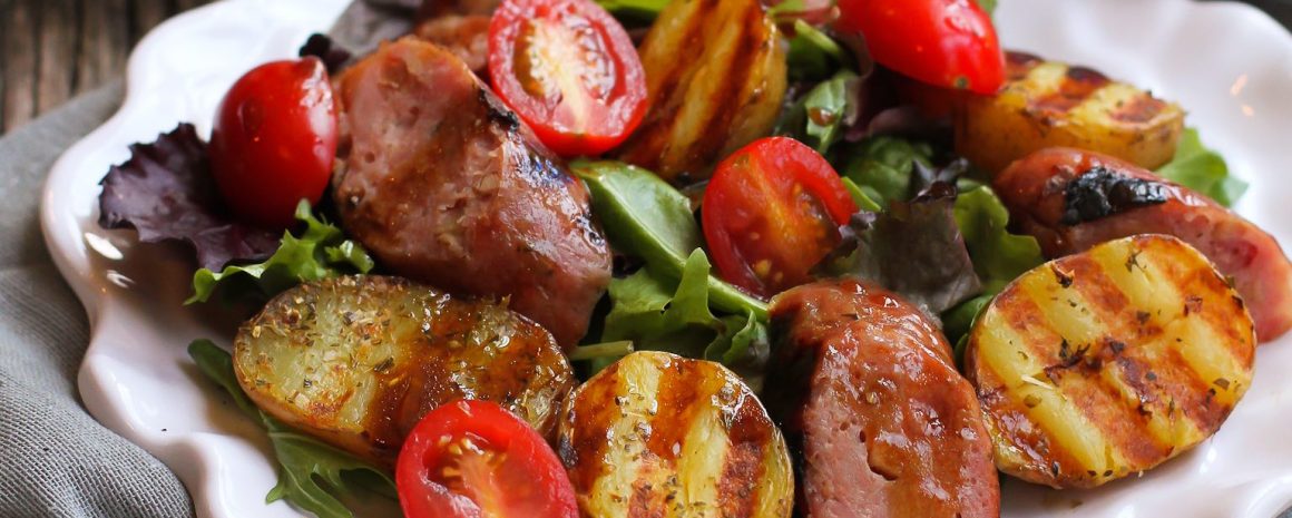 Grilled sausage, potato, and mixed green salad.