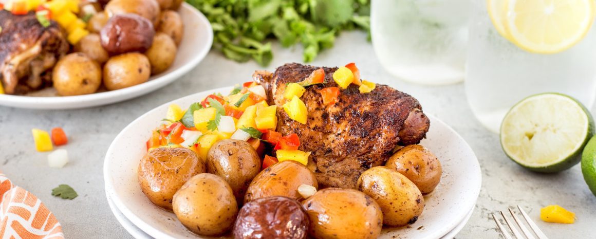 A plate of potatoes and jerk chicken.