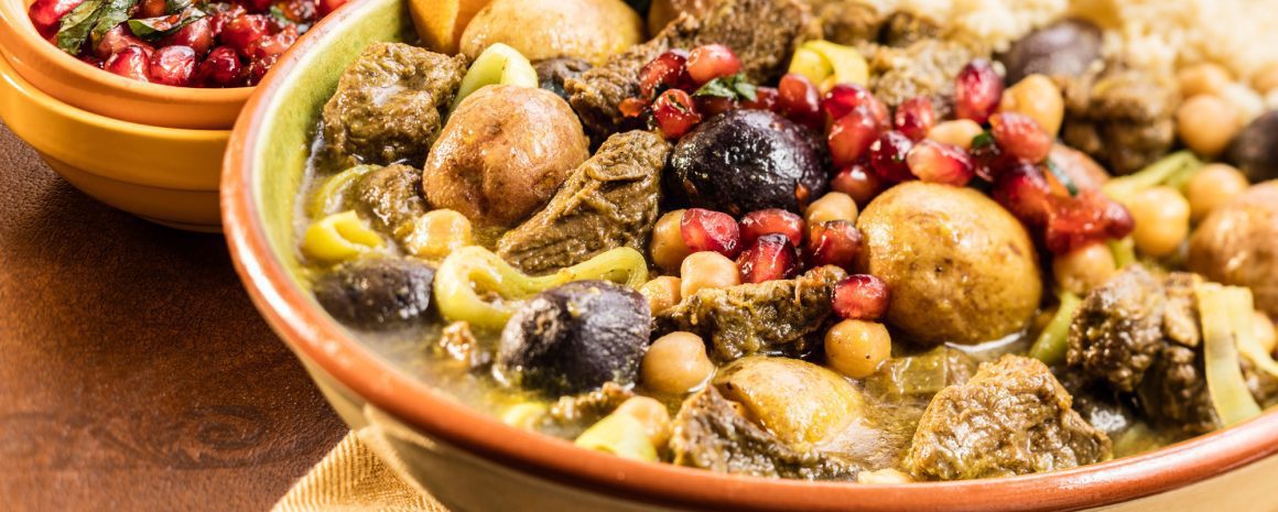 A bowl of stew with lamb and veggies.