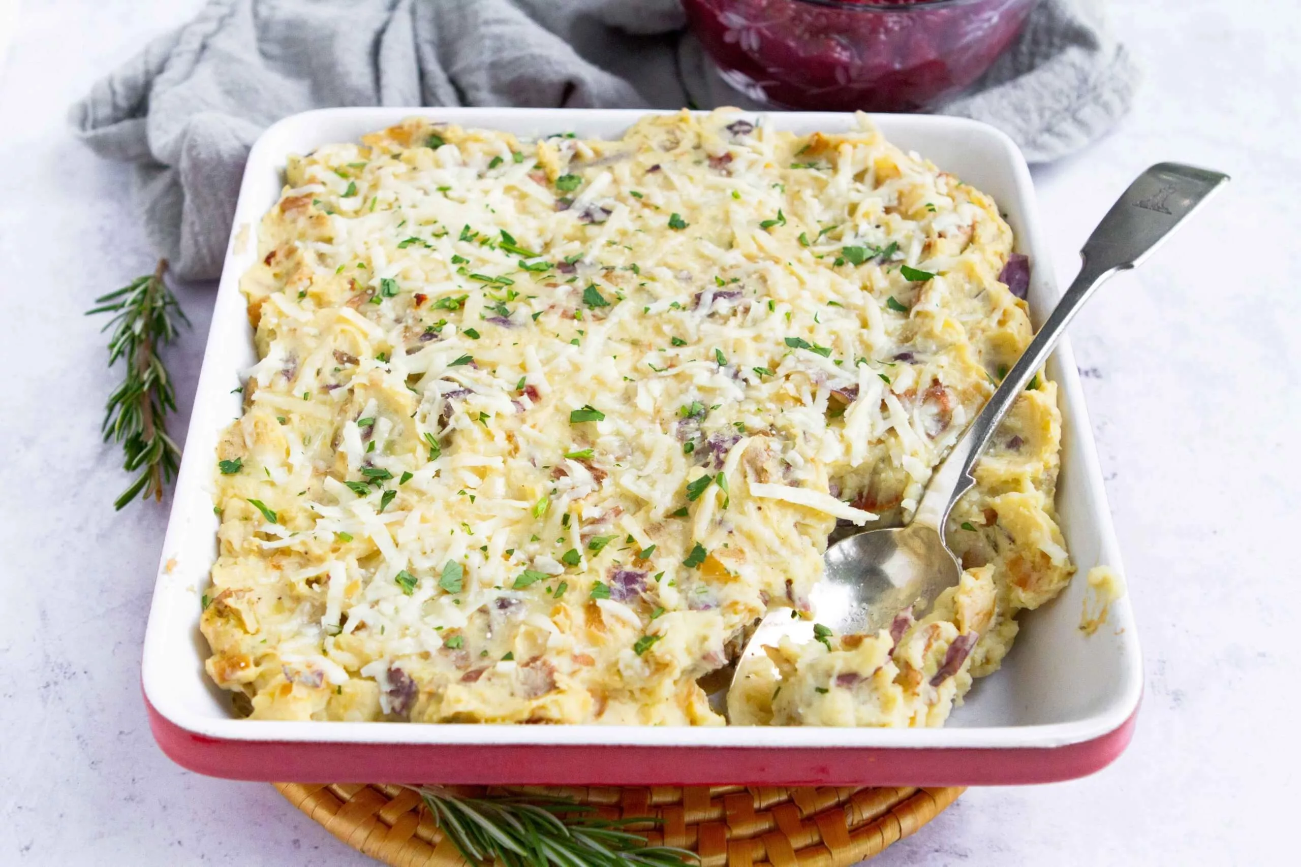 A dish of loaded mashed potato casserole with bacon.
