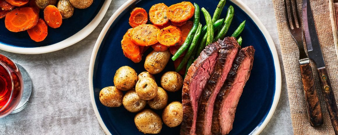 A nice full plate of flank steak, little potatoes, carrots, and beans.