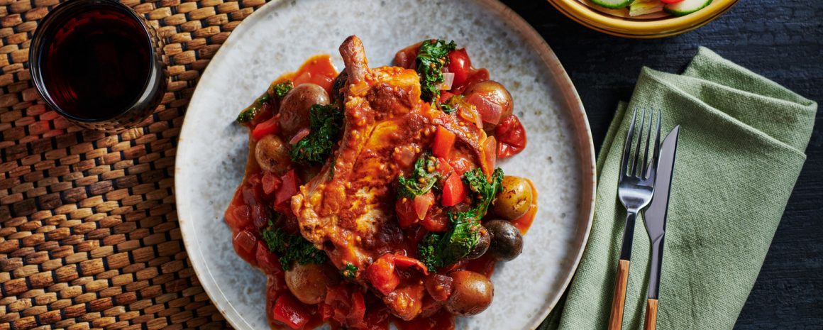 Pork chops and potatoes in at tomato pepper sauce.