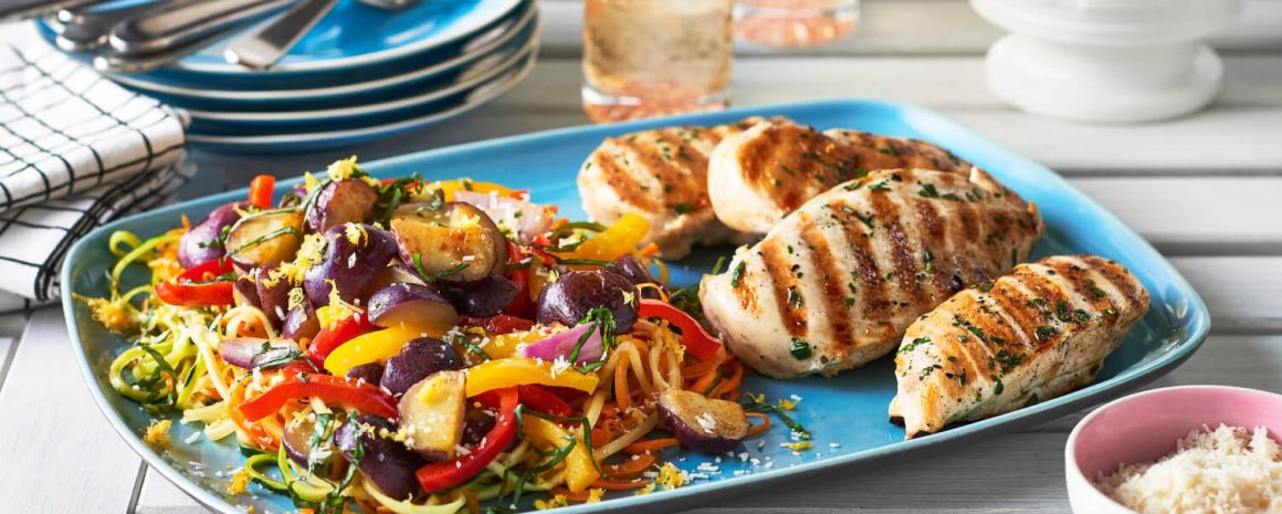 A plate of spiralized veggies with grilled chicken.