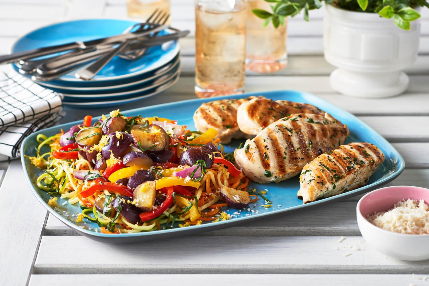 A plate of spiralized veggies with grilled chicken.
