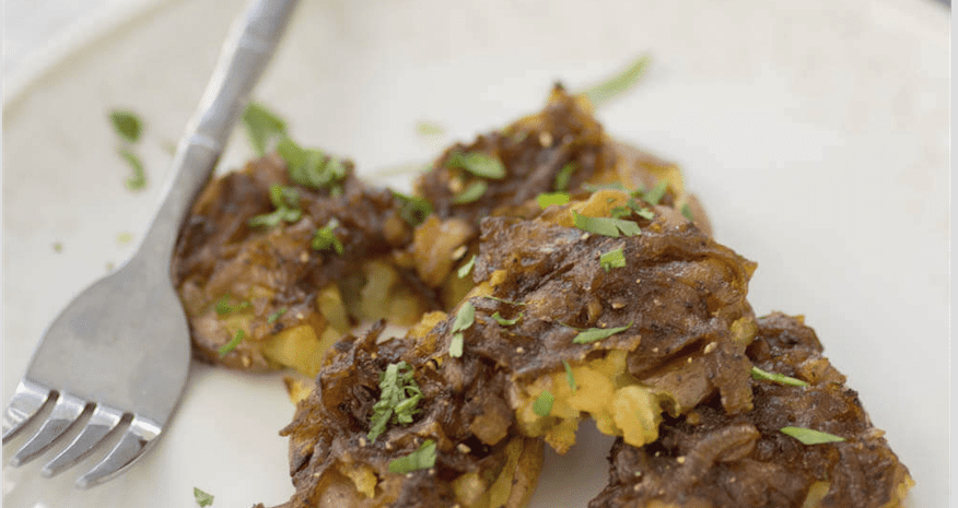 Petites pommes de terre écrasées avec des échalotes en sauce