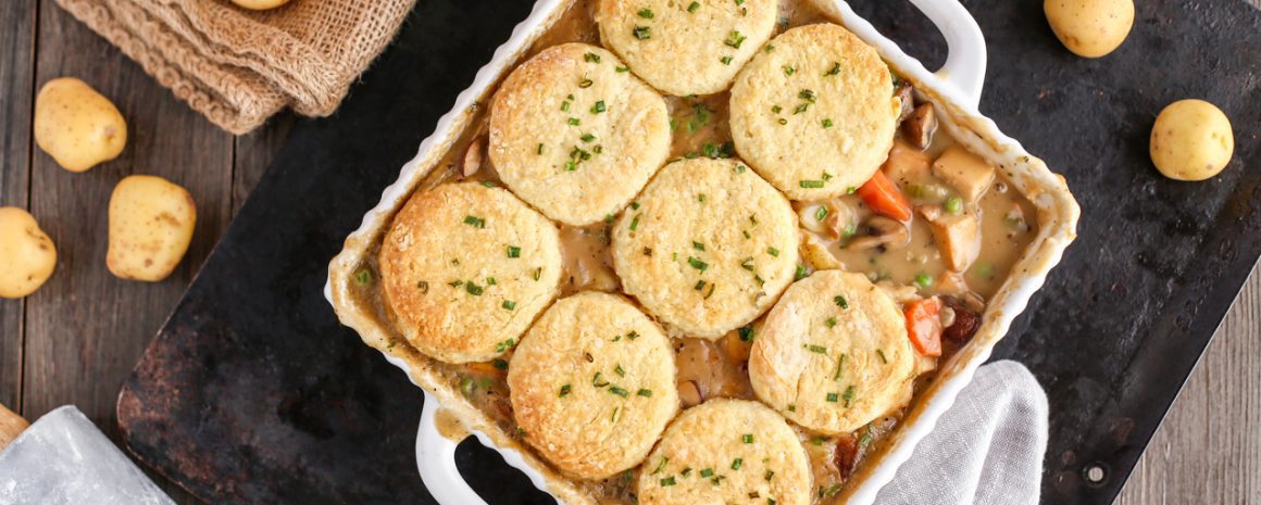 Biscuits atop a dish of vegetable pot pie.