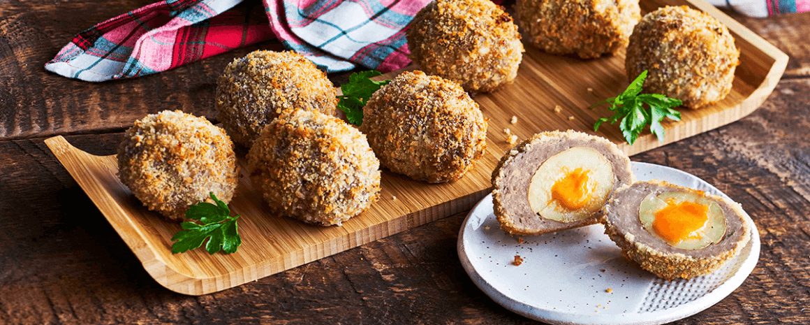 A plate of little potatoes breaded and stuffed with cheese.