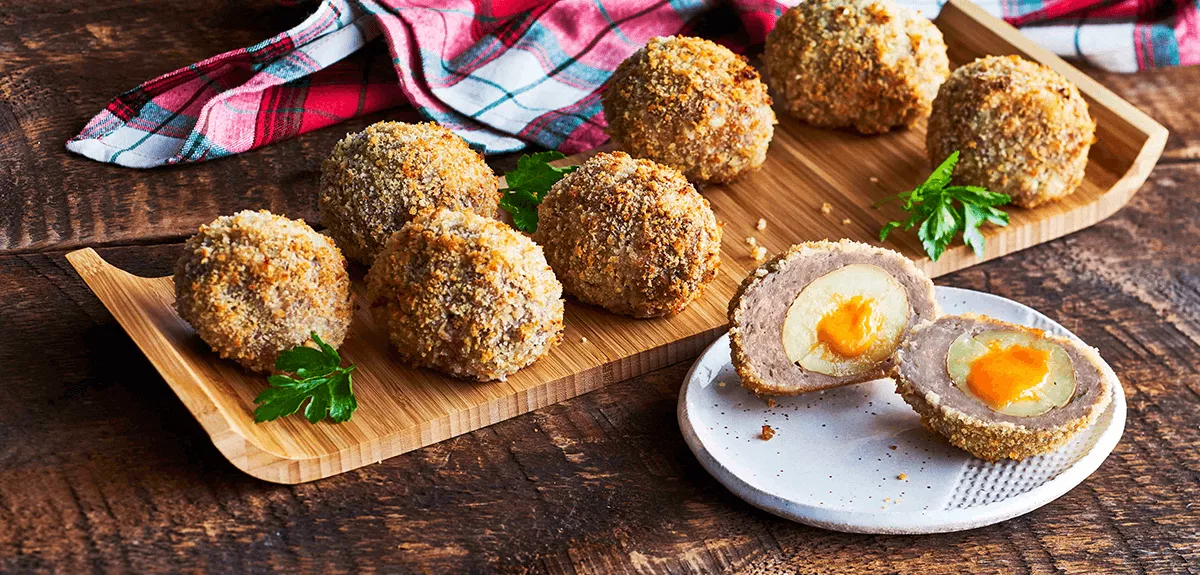 A plate of little potatoes breaded and stuffed with cheese.