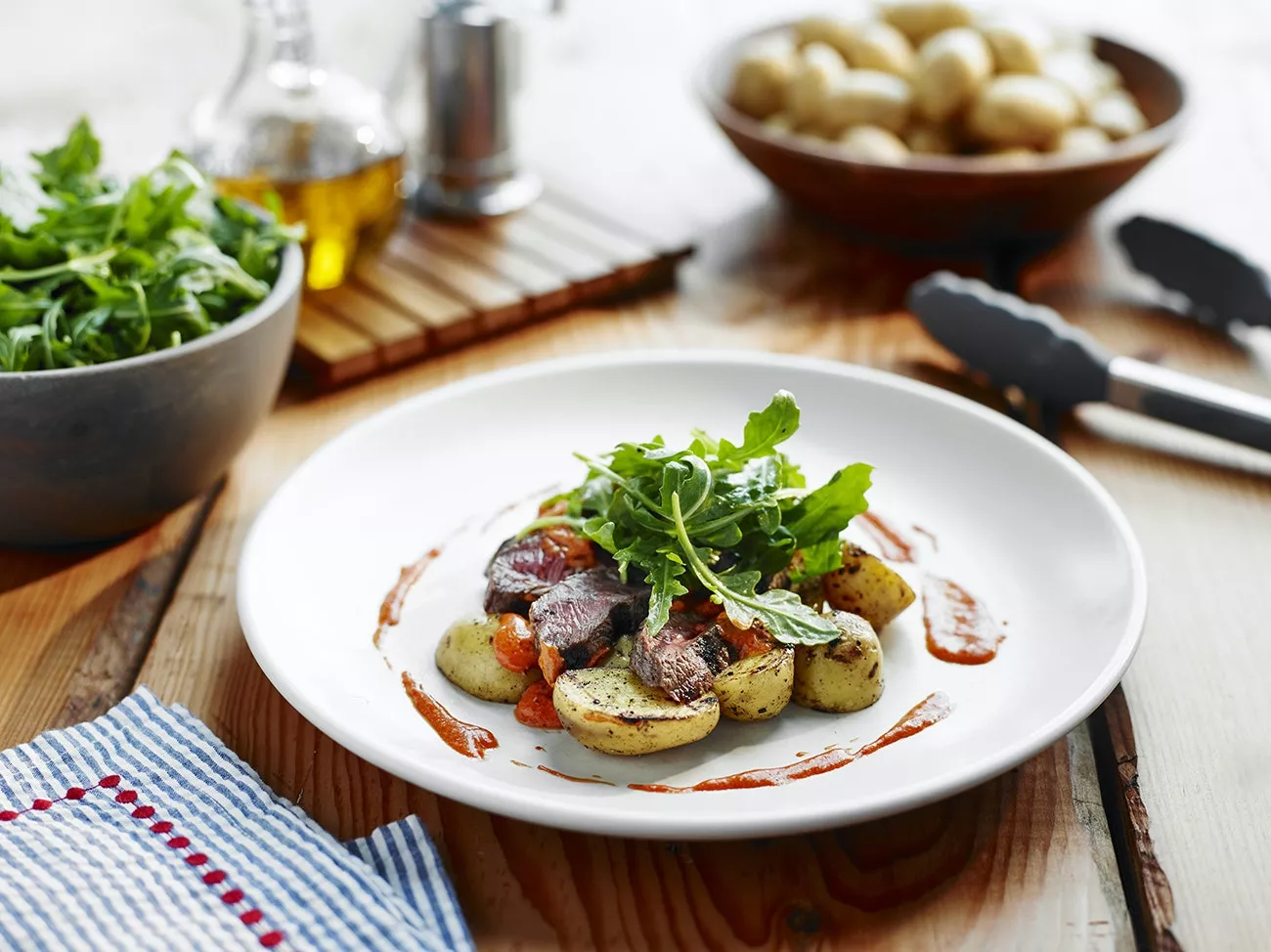 A plate of steak and Little Potatoes with Romesco sauce.