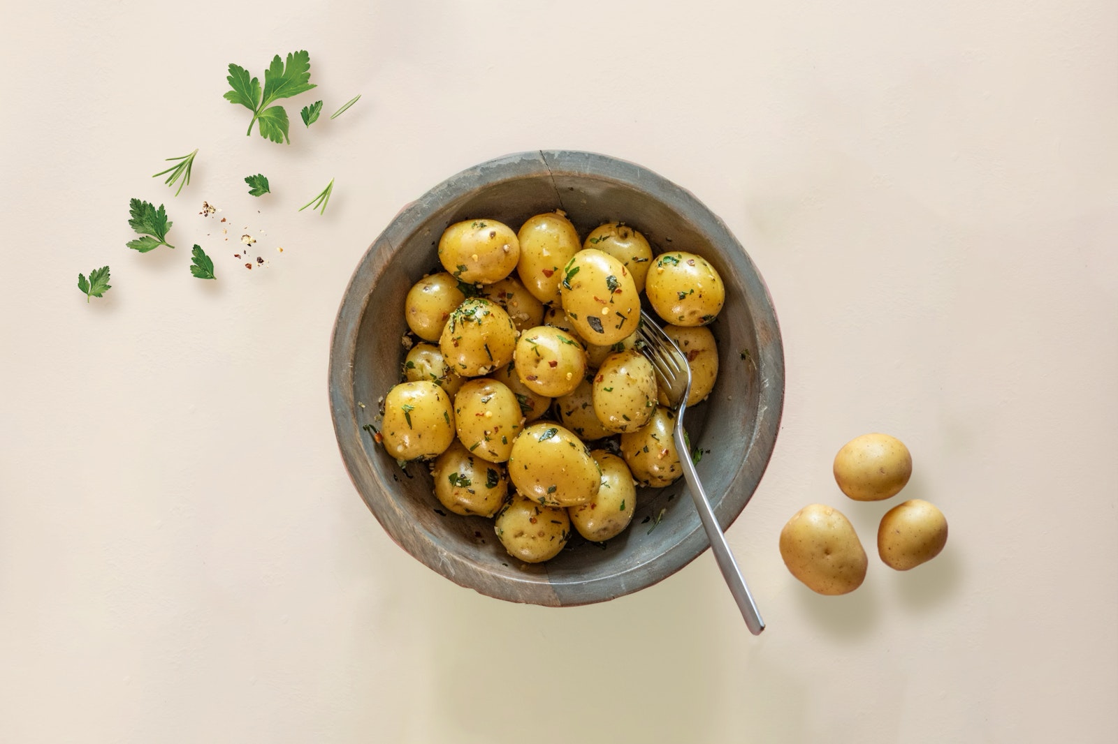 A bowl of Little Yellows™ Little Potatoes on a cream background.